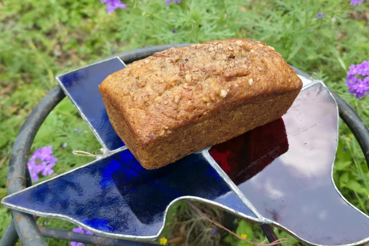 Top-down view of a Signature Banana loaf on a stained-glass stand in a meadow